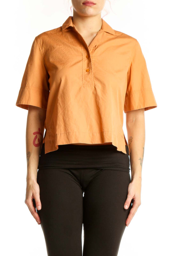 Orange cotton short sleeve polo shirt with button-front closure and cropped silhouette