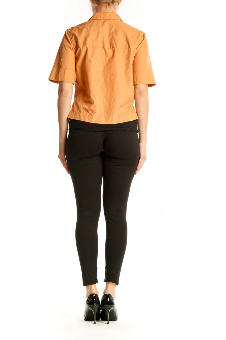 Back view of orange cotton polo shirt showing relaxed fit and button details