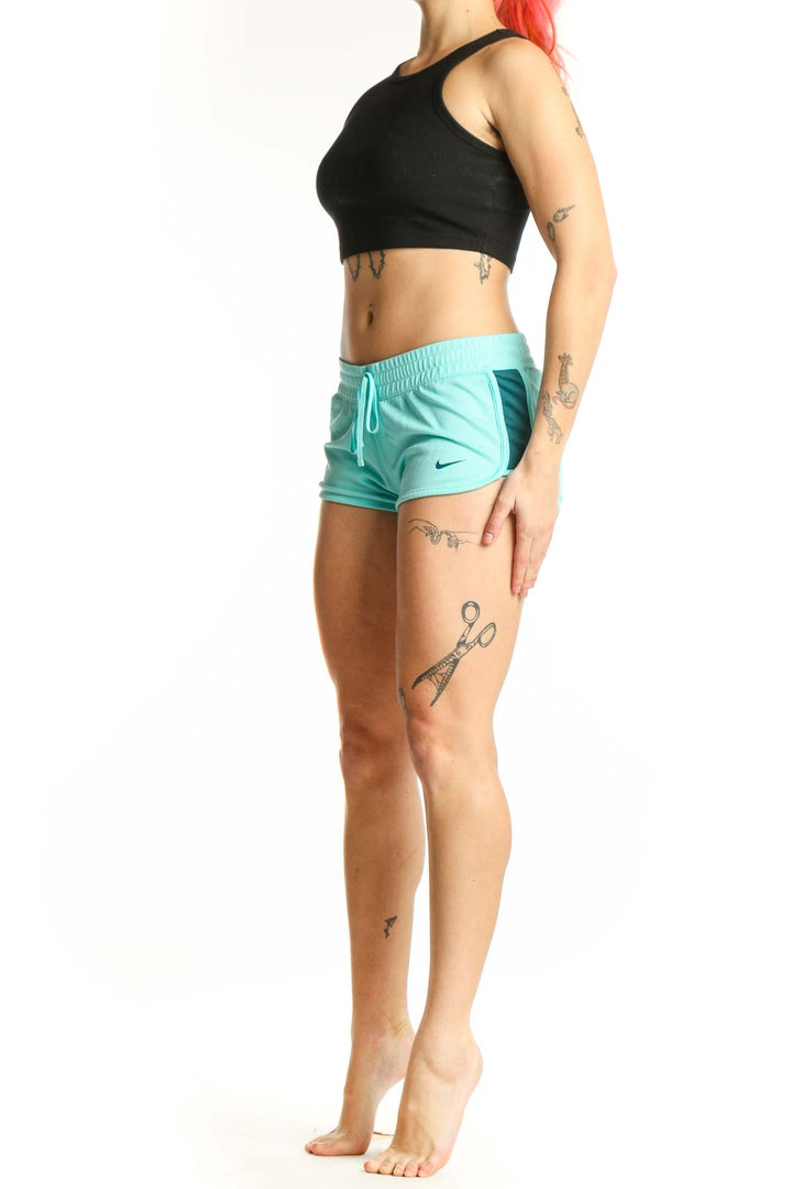 Front view of turquoise Nike athletic shorts with adjustable drawstring and Nike Swoosh logo