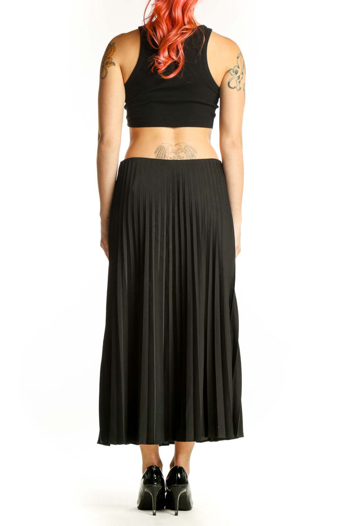 Black pleated midi skirt back view displaying full pleated design and midi length