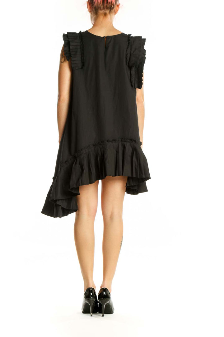 Back view of black ruffled asymmetrical dress showing dramatic side ruffle and A-line silhouette