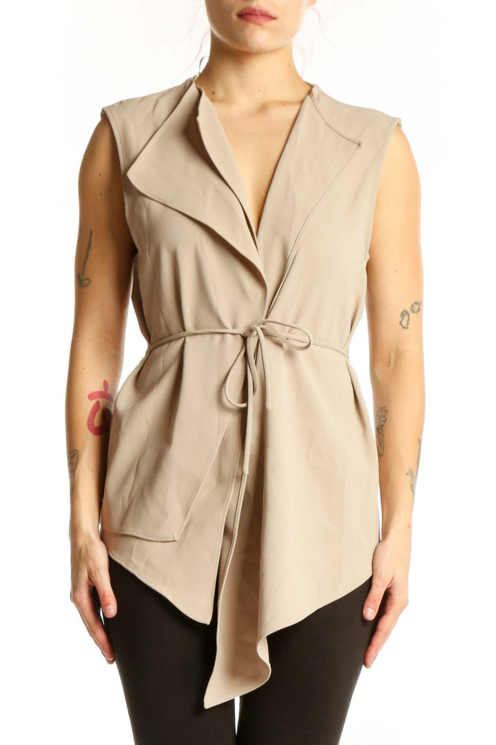 Beige sleeveless wrap vest top with tie waist and asymmetrical hem, front view on model