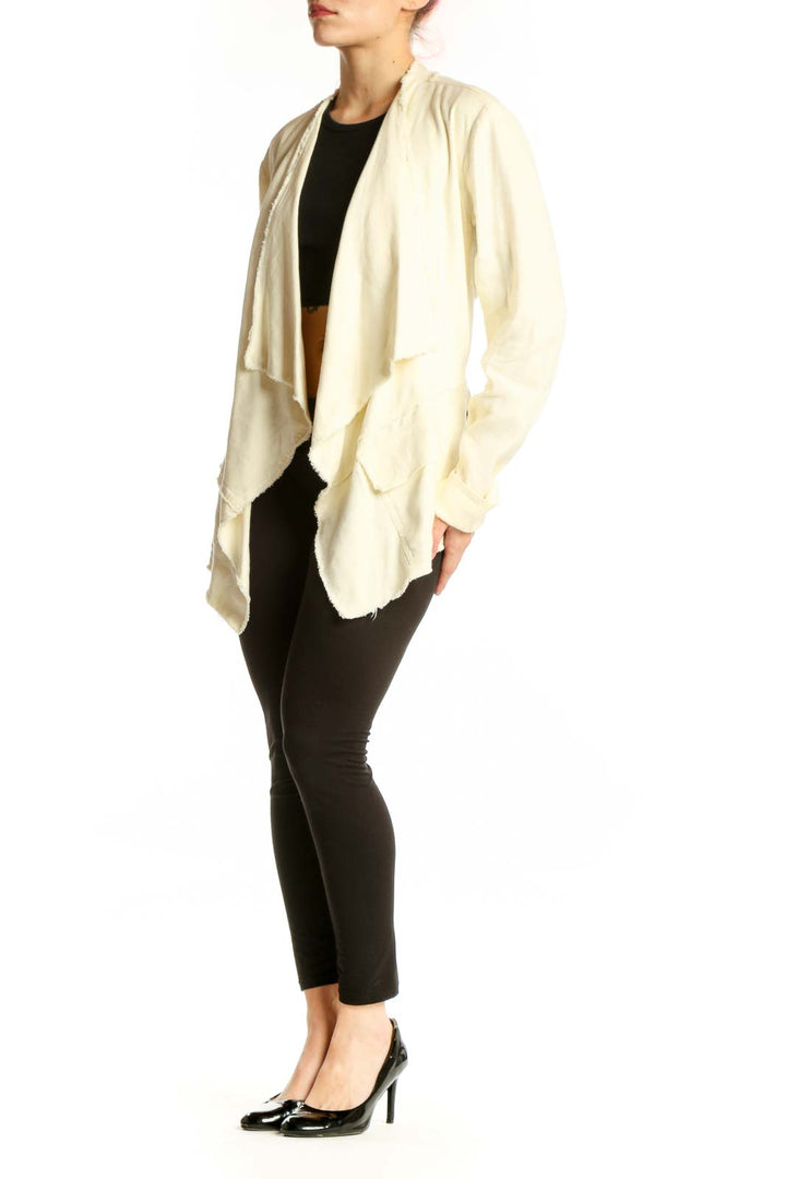 Cream draped cardigan jacket by Free People worn open over black top, showcasing flowing front design and relaxed fit