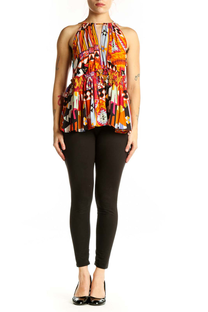 Front view of multicolor abstract halter top with bold geometric and striped patterns in orange, red, yellow, and black