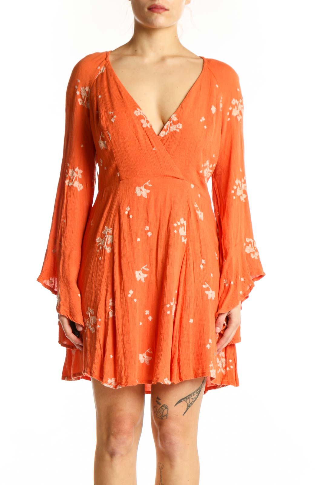 Front view of orange floral wrap dress with bell sleeves and V-neckline by Free People