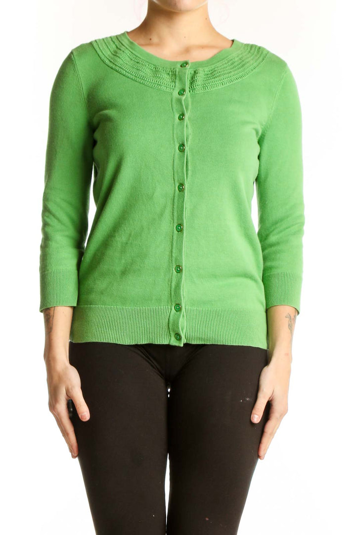 Green button-front cardigan with crew neckline and ribbed detailing, worn with black pants