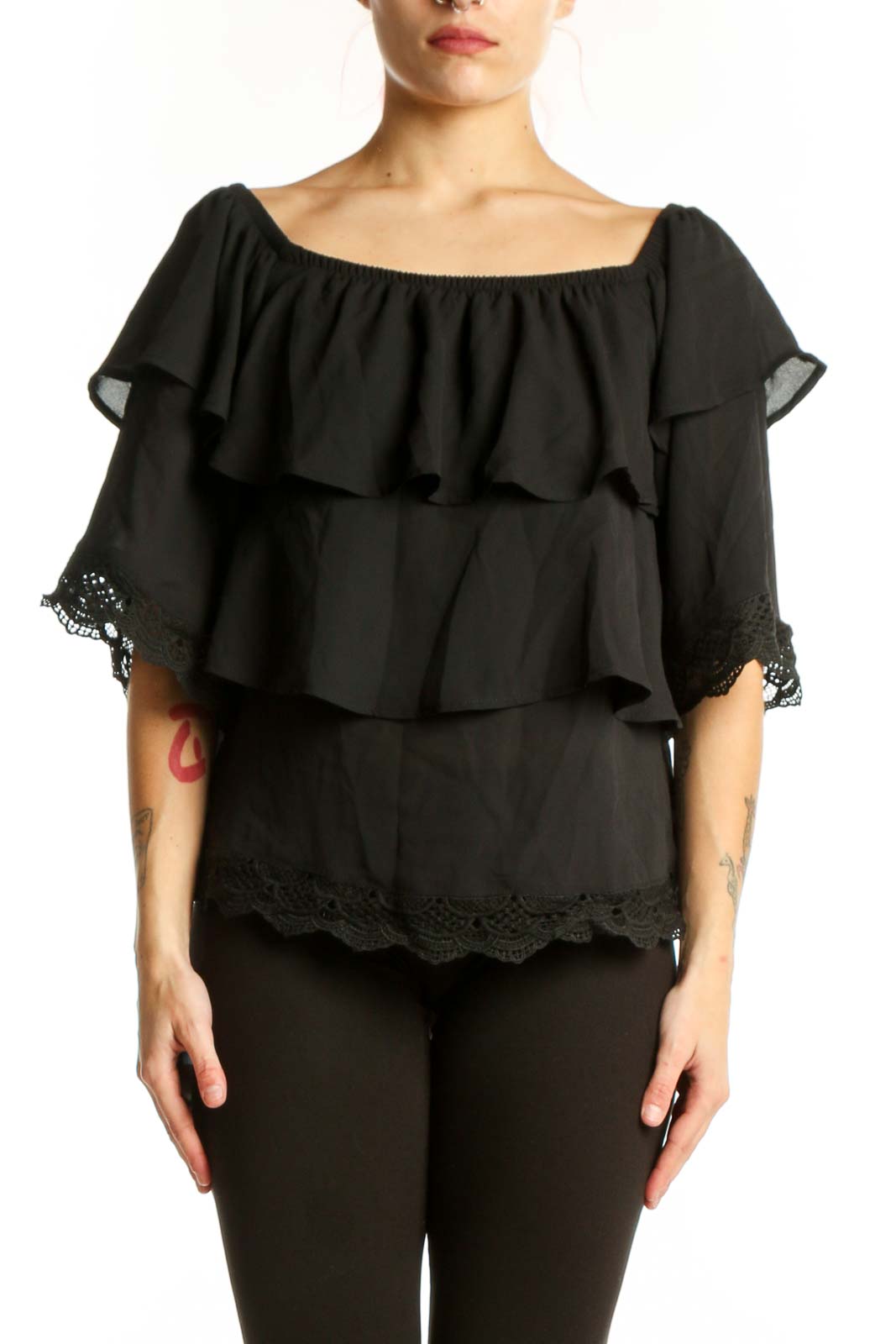 Black off-shoulder ruffled top with lace trim and layered tiers, front view on model