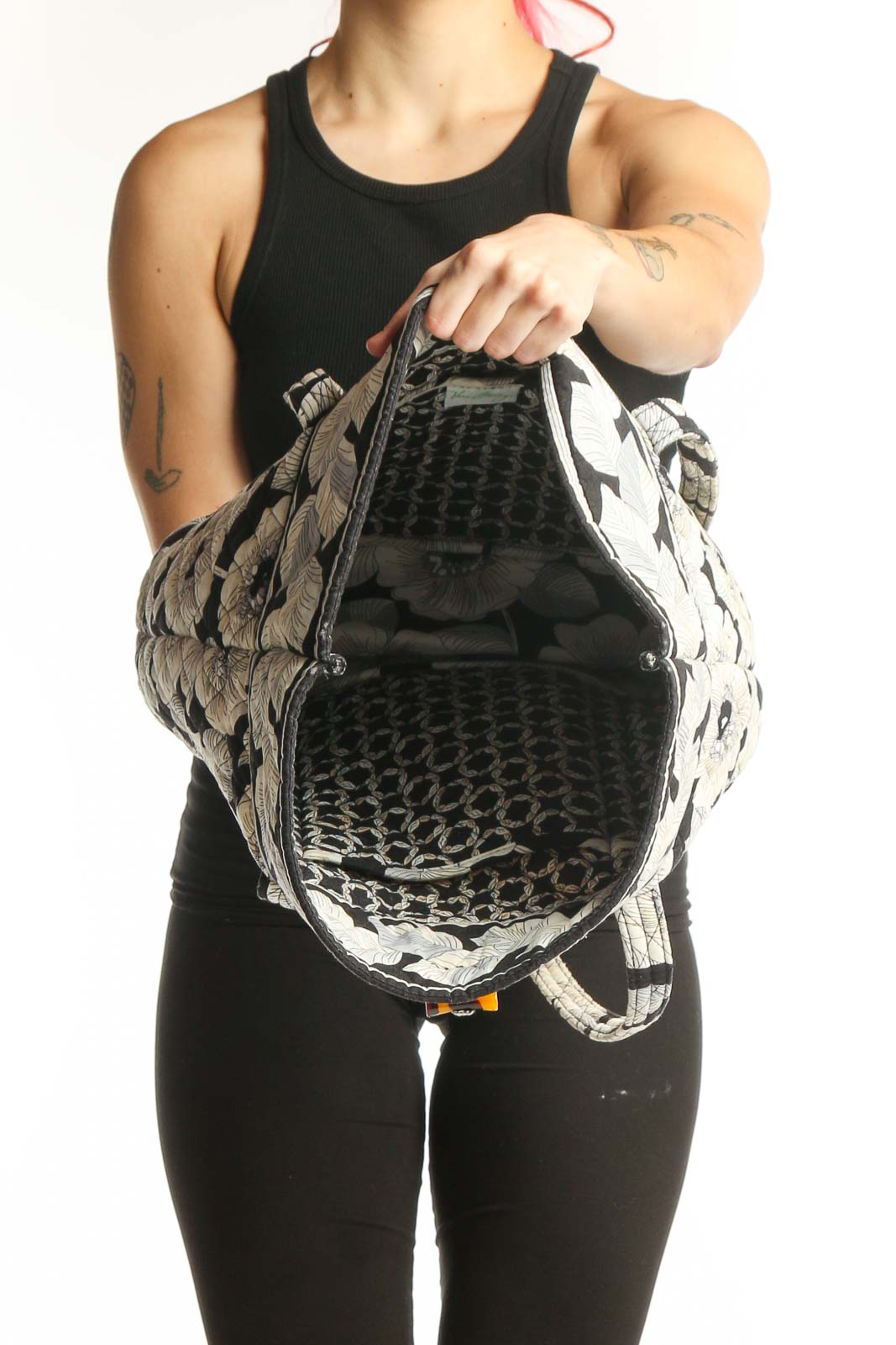 Black and cream botanical patterned Vera Bradley tote bag worn on shoulder, back view