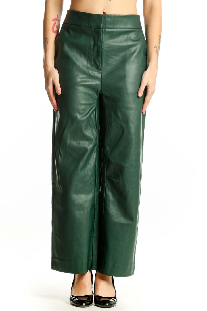 Front view of green leather wide leg pants with high waisted design and flowing silhouette