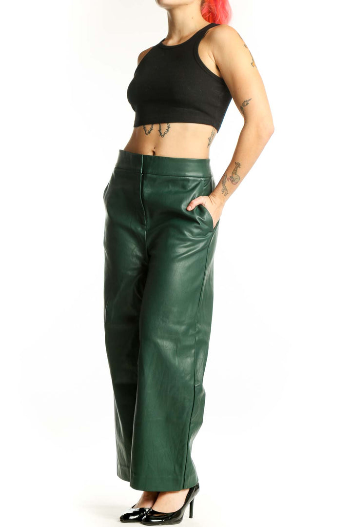 Front view of green leather wide leg pants with high waisted design and flowing silhouette