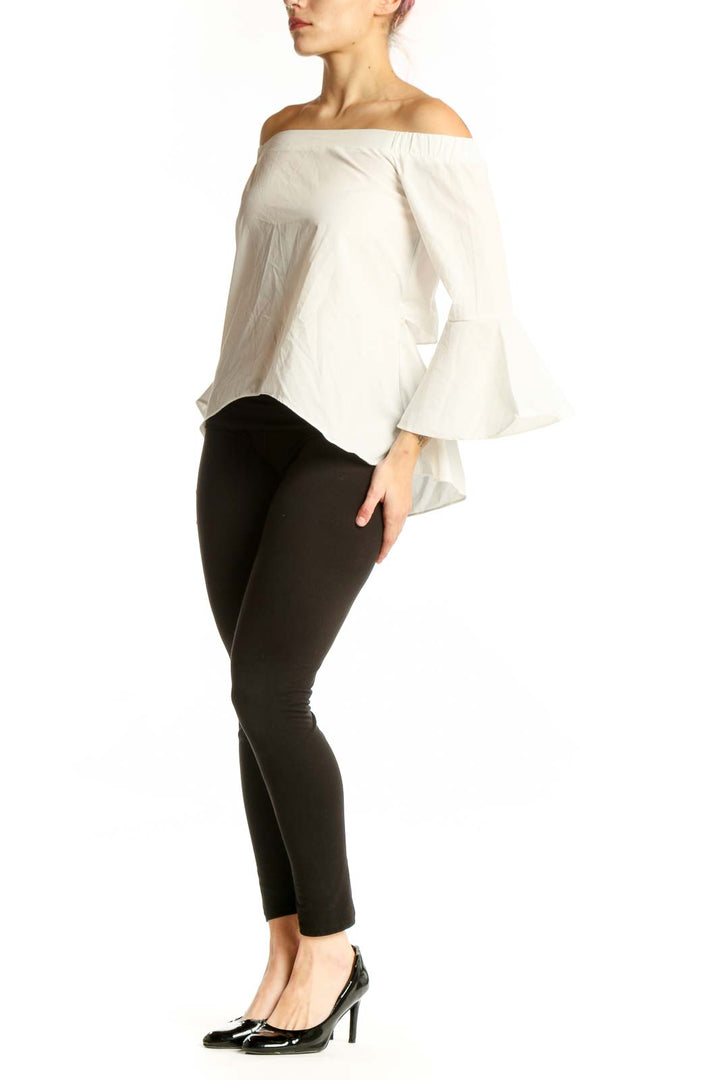 Cream off-shoulder bell sleeve cotton top with asymmetrical hem, front view on model