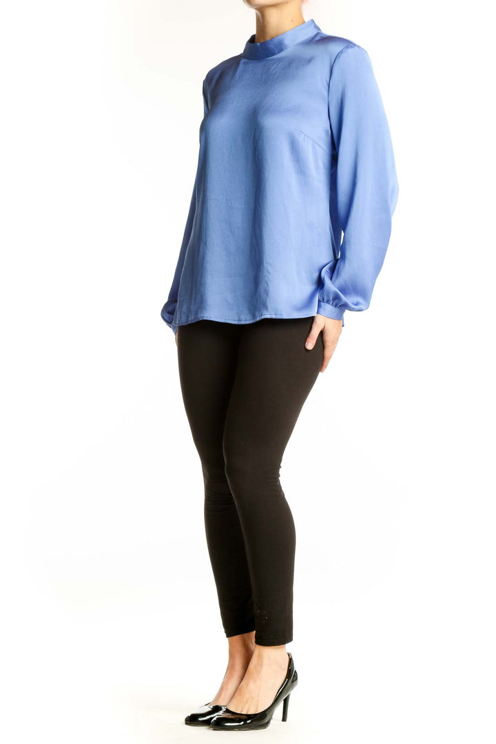Front view of blue mock neck polyester blouse with long sleeves and gathered cuffs