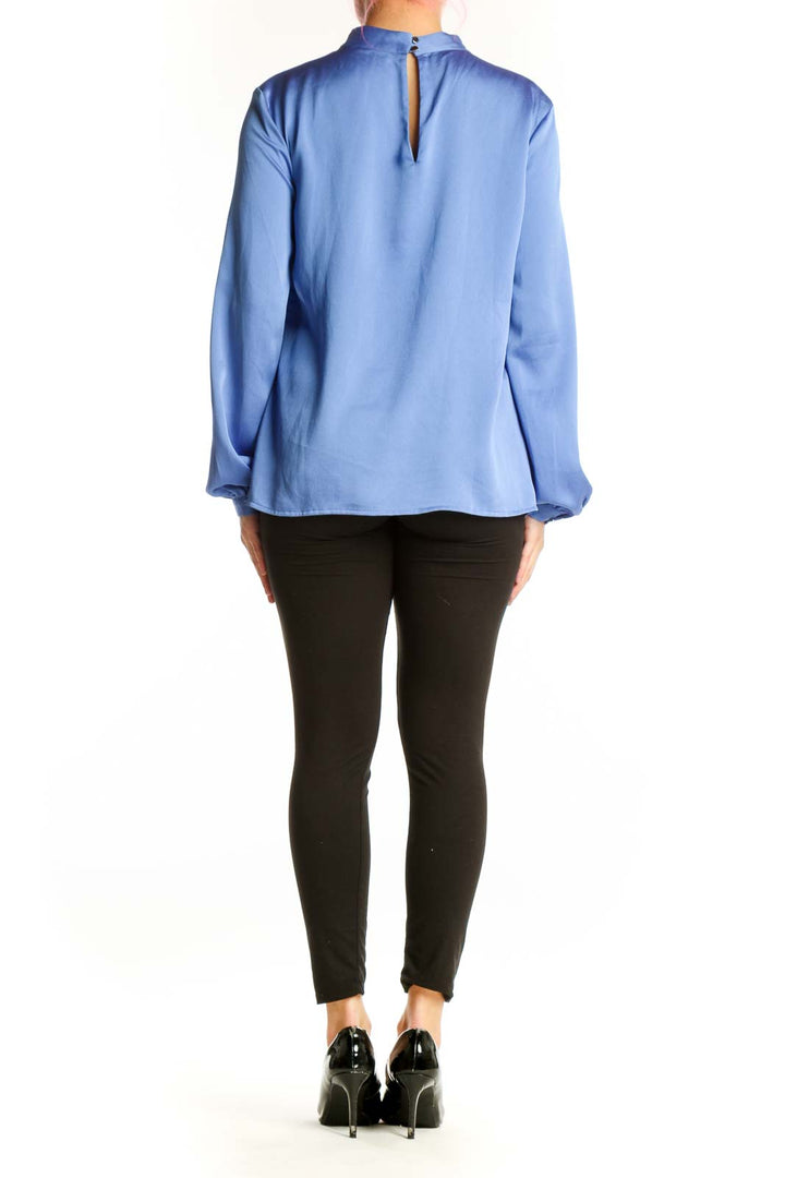 Back view of blue mock neck polyester blouse showing relaxed fit and sleeve detail