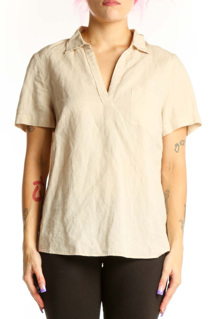 Front view of cream linen short sleeve polo top with collared neckline and chest pocket detail