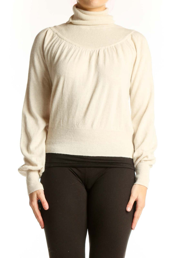 Cream turtleneck pullover sweater with gathered shoulders and cropped fit, front view