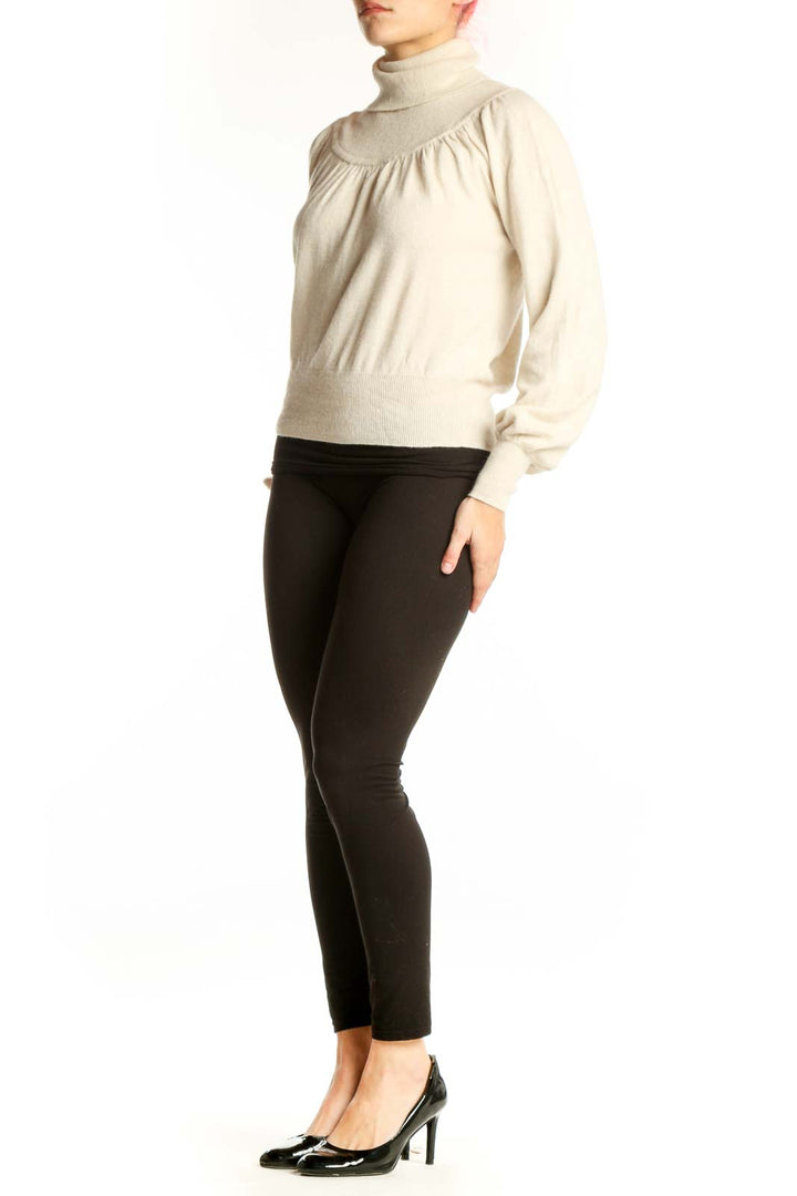 Cream turtleneck pullover sweater with gathered shoulders and cropped fit, front view