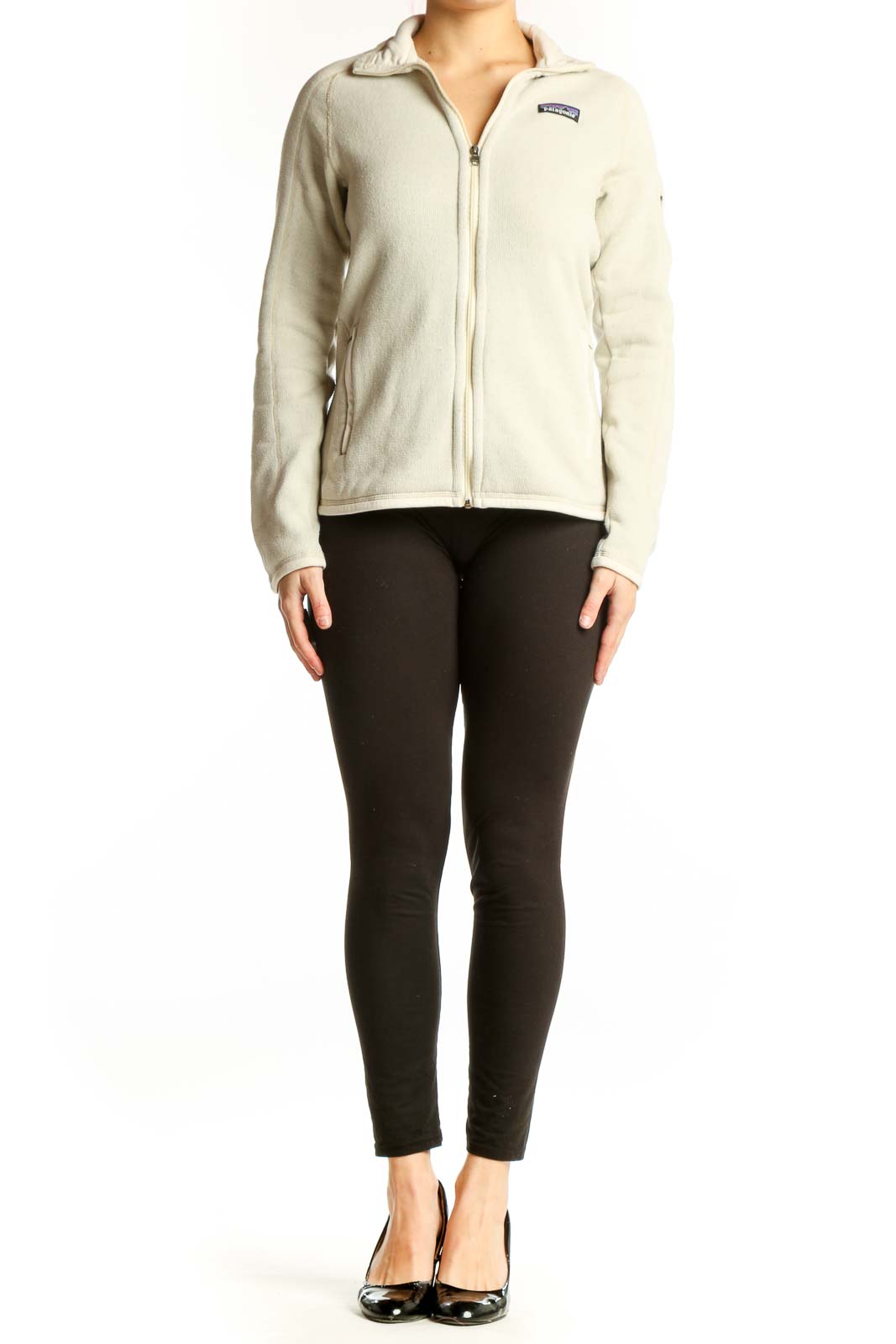 Front view of cream Patagonia fleece zip jacket with hood on woman wearing black leggings