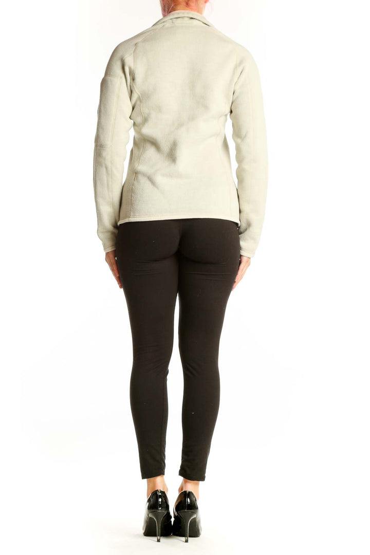 Back view of cream Patagonia fleece zip jacket with hood on woman in profile