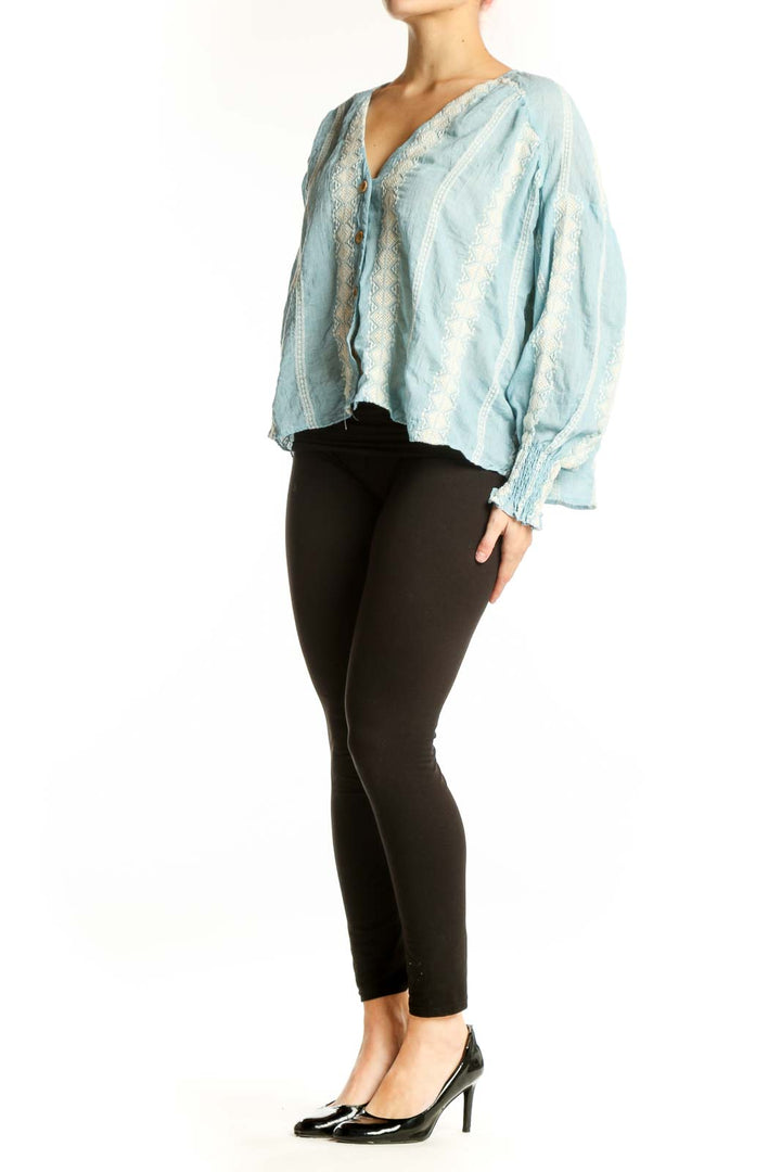 Light blue lace button-up cropped blouse with puffed sleeves and cream lace detailing, front view