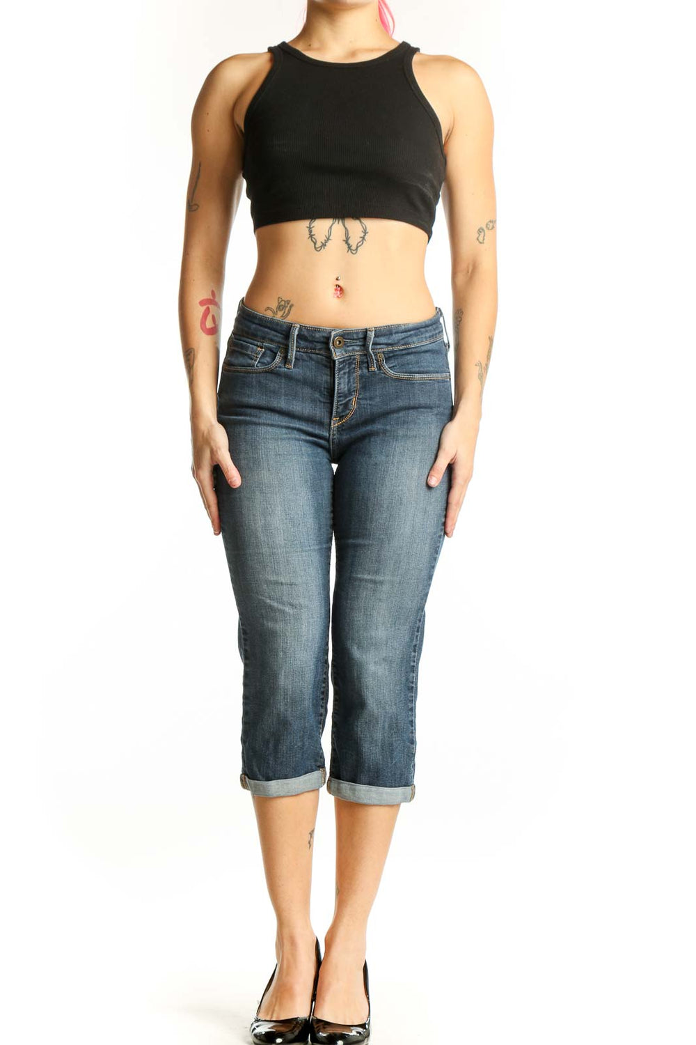 Front view of blue denim capri jeans with rolled cuffs and mid-rise fit on model