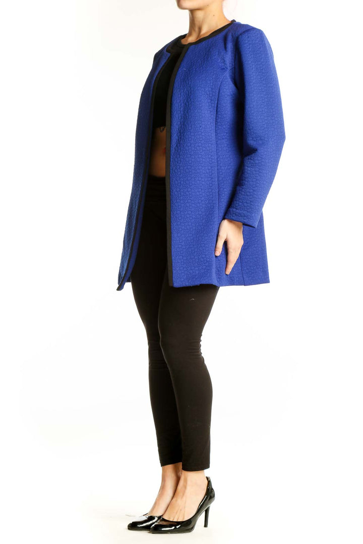 Blue open front cardigan jacket with black ribbed neckline, worn with black crop top and black pants