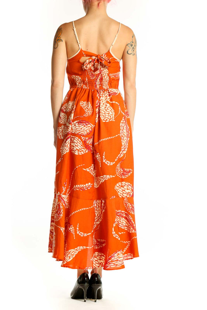 Back view of orange floral wrap midi dress showing asymmetrical hemline and wrap-style design