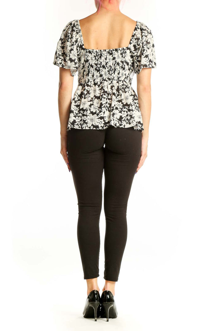 Black and white floral puff sleeve top with flutter sleeves, back view