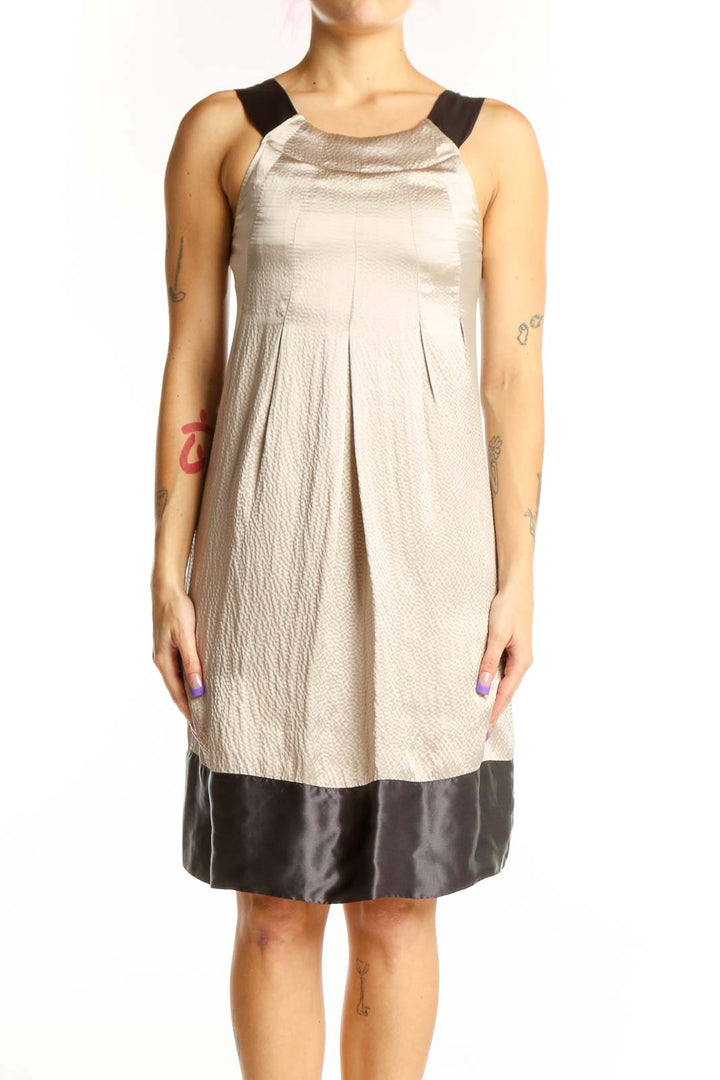 Front view of cream and black colorblock dress by Ted Baker London with pleated bodice and black shoulder trim