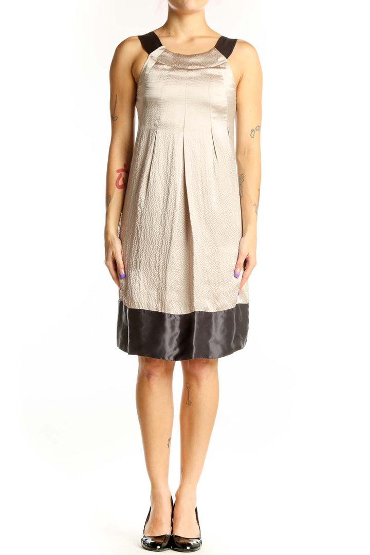 Front view of cream and black colorblock dress by Ted Baker London with pleated bodice and black shoulder trim