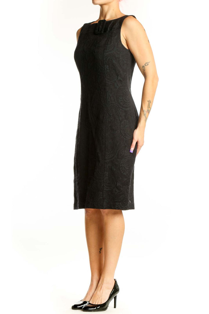 Black jacquard sleeveless sheath dress with crew neckline and buckle shoulder detail, front view