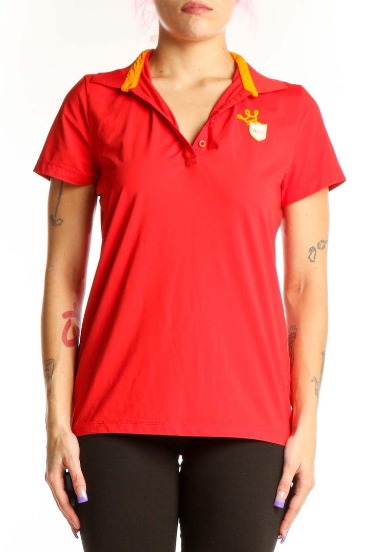 Red polo short sleeve top with yellow collar trim and branded emblem, front view on model