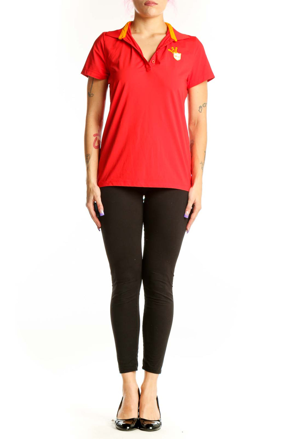 Red polo short sleeve top with yellow collar trim and branded emblem, front view on model