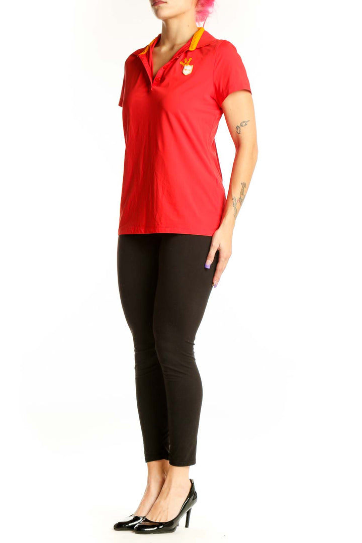 Red polo short sleeve top with yellow collar trim and branded emblem, front view on model