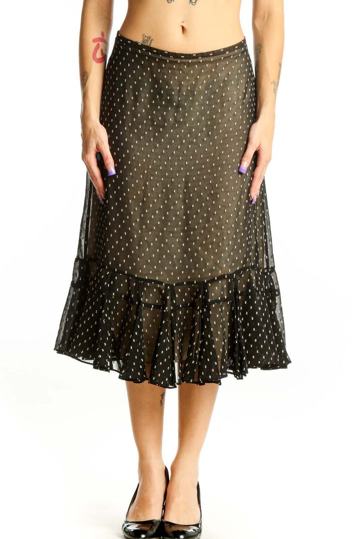 Black polka dot midi skirt with gold dots and ruffled hem, front view on model