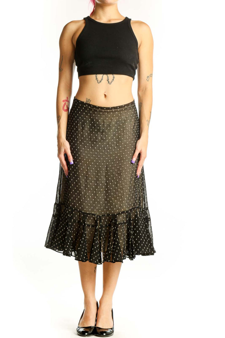 Black polka dot midi skirt with gold dots and ruffled hem, front view on model