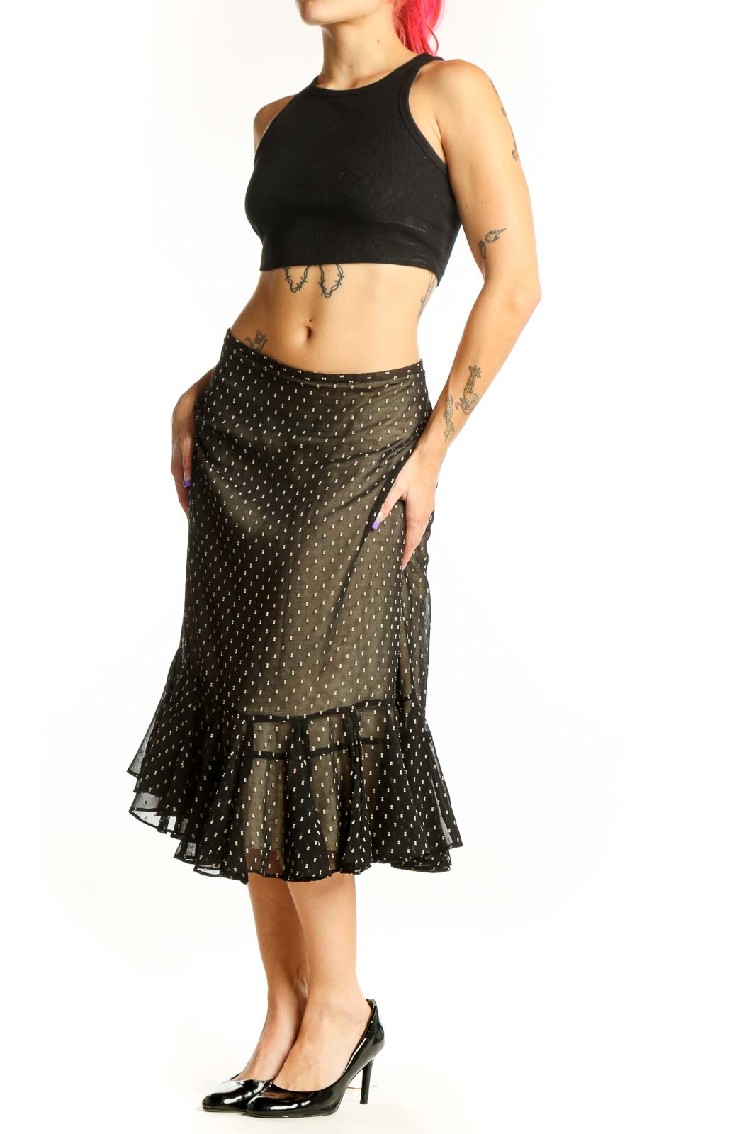 Black polka dot midi skirt with gold dots and ruffled hem, front view on model