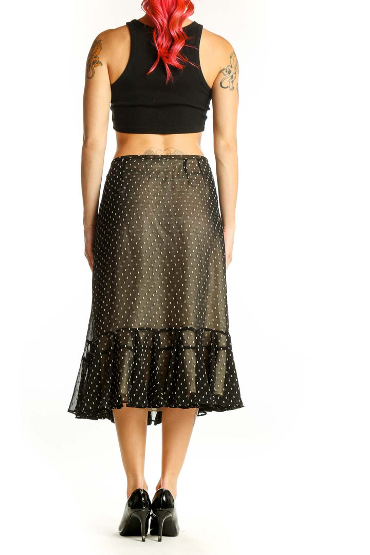 Black polka dot midi skirt with ruffled hem, back view on model