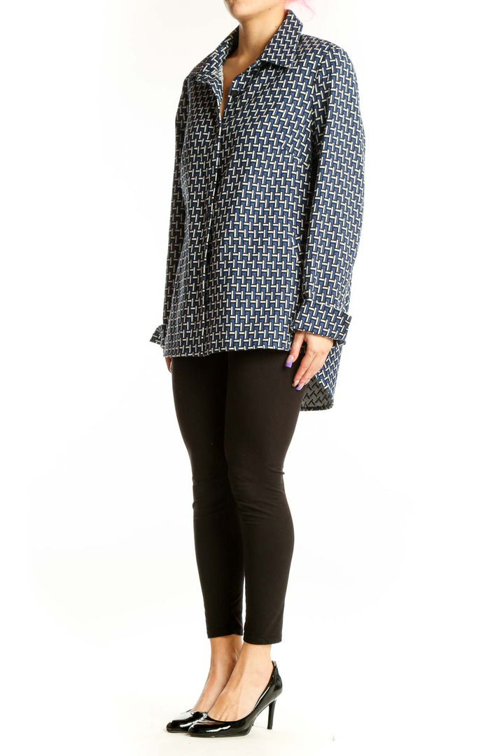 Navy geometric print button-up jacket with white pattern, long sleeves, and collared neckline worn with black pants