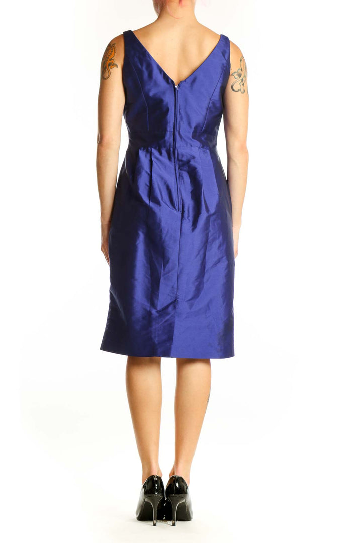Navy blue satin cocktail dress with ruched neckline and embellished waist detail, back view