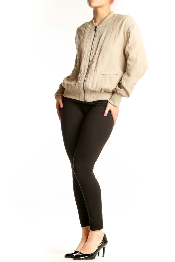 Front view of cream quilted bomber jacket with full zip closure and side pockets