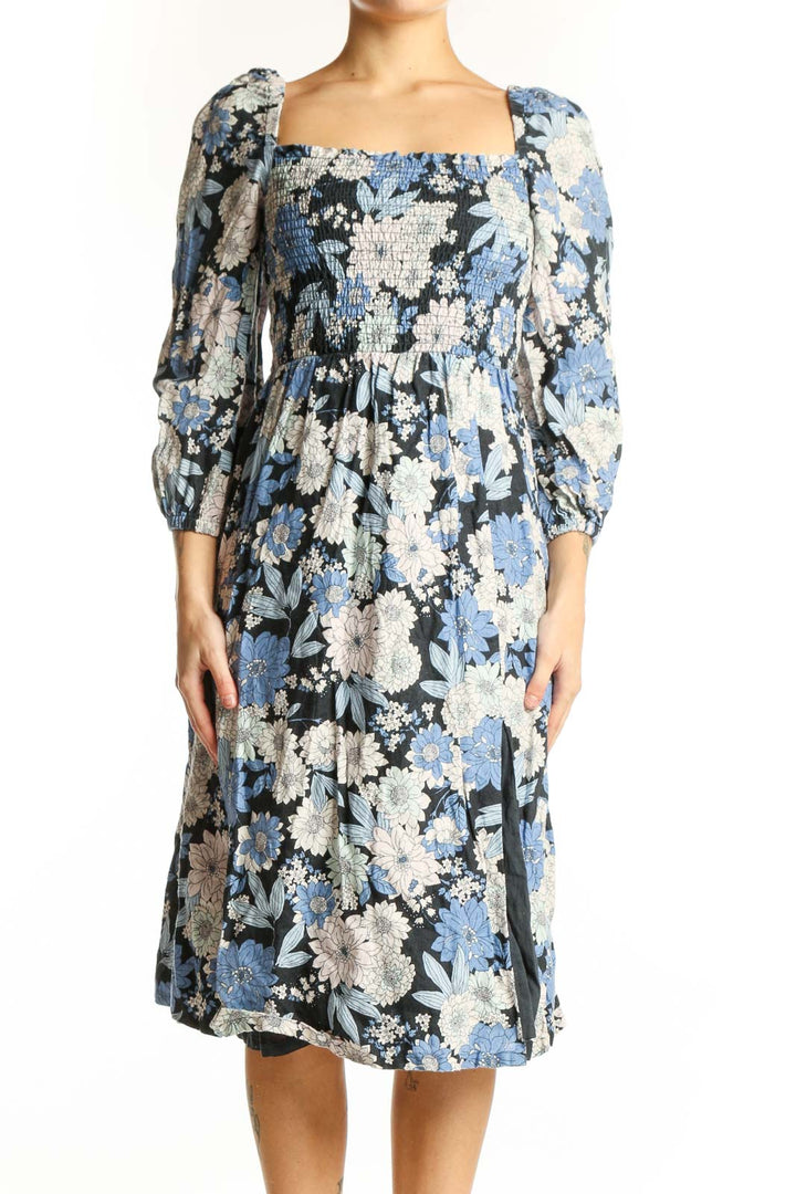 Front view of blue floral midi dress with puff sleeves and smocked square neckline