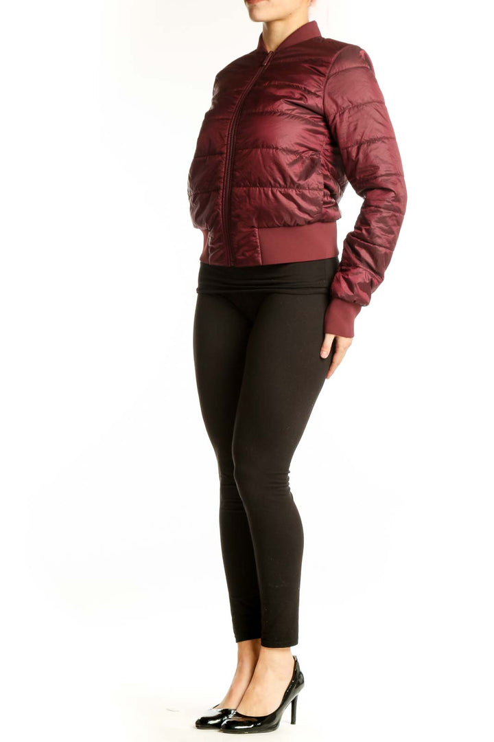 Burgundy quilted puffer bomber jacket with full-length zipper and ribbed cuffs, worn with black leggings