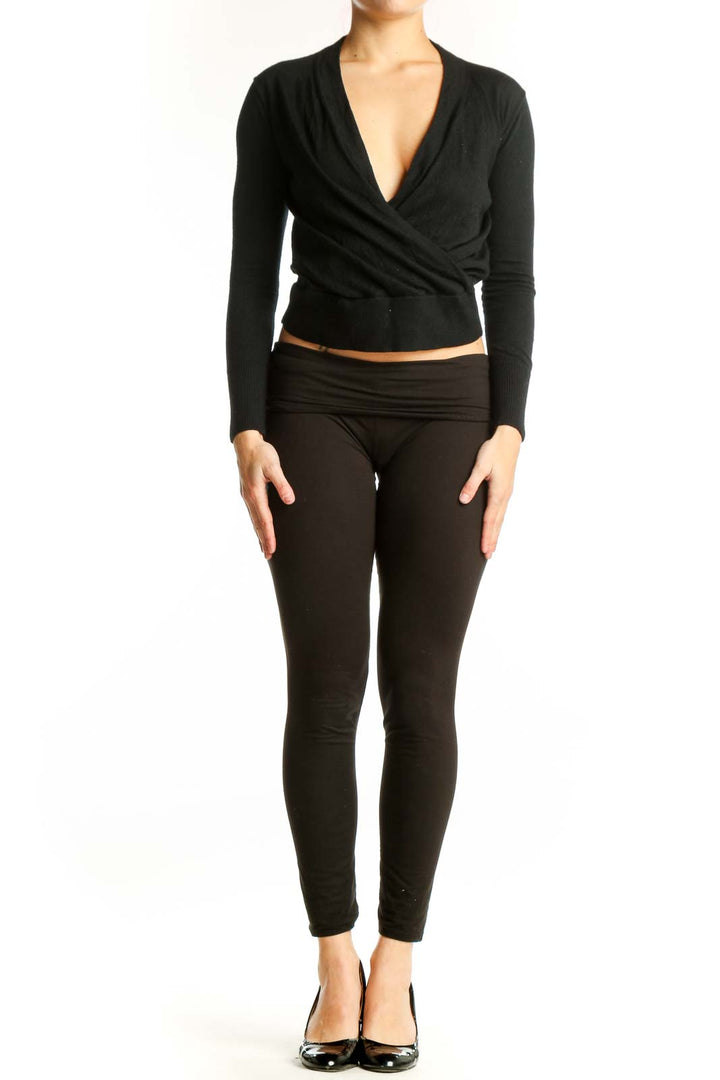 Black Merino Wool wrap crop top with V-neckline and wrap-front design, shown on model from front