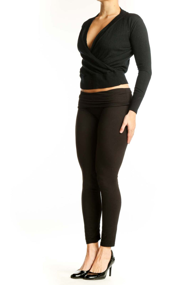 Black Merino Wool wrap crop top with V-neckline and wrap-front design, shown on model from front
