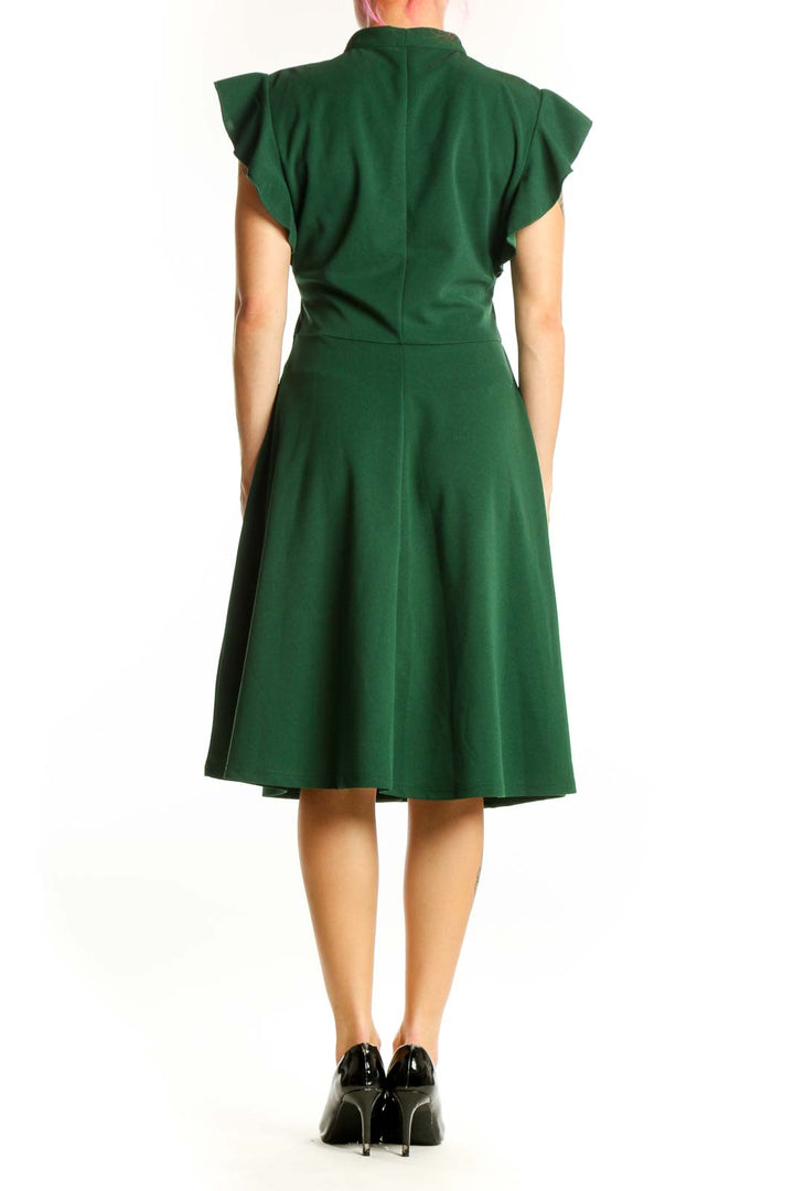Back view of green tie neck cap sleeve midi dress showing flowing silhouette