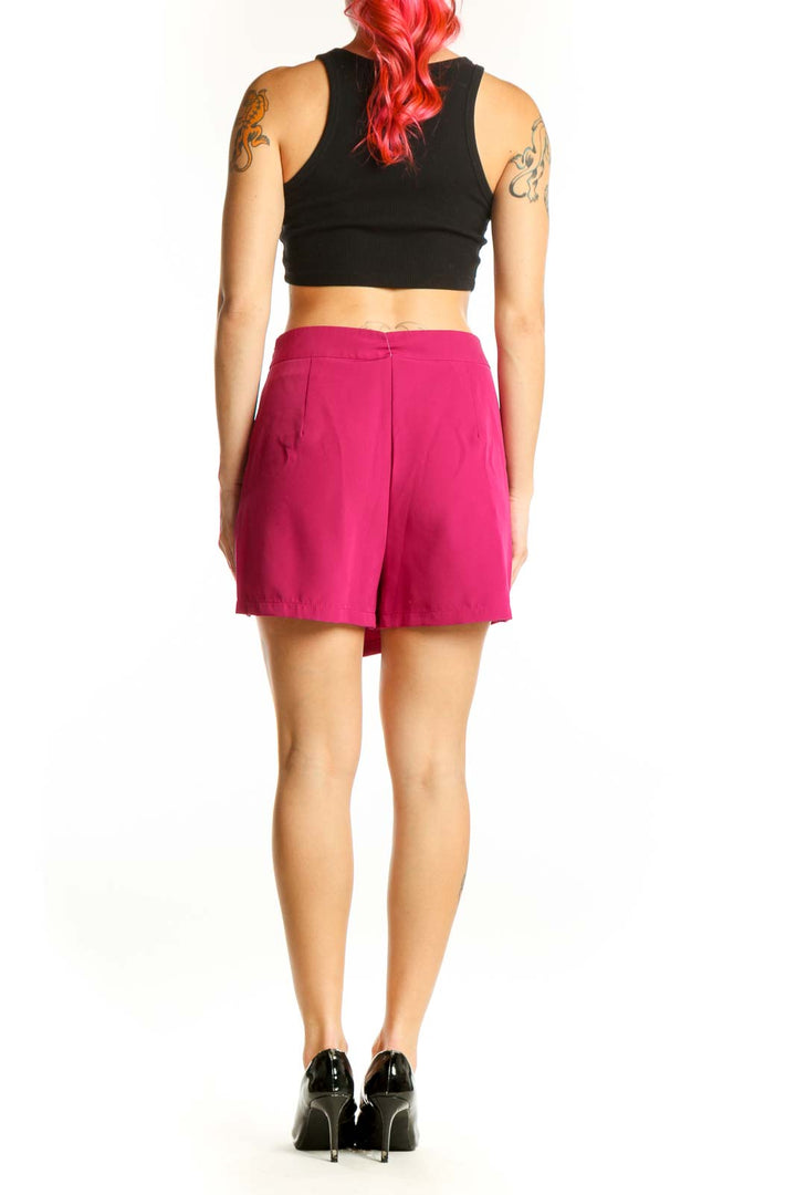 Back view of pink asymmetrical shorts showing asymmetrical hemline and fit