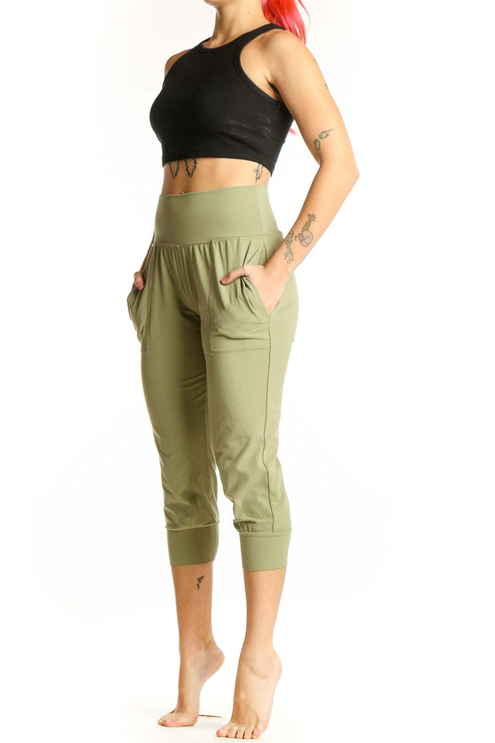 Front view of sage green Athleta capri pants with high waistband and side pockets on model