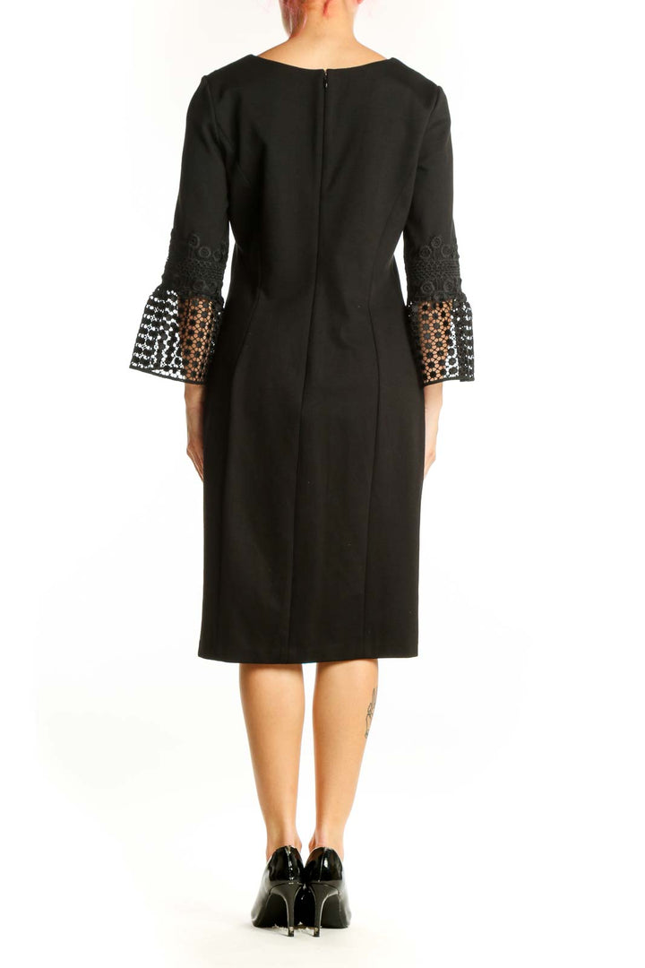 Back view of black lace bell sleeve midi dress showing elegant drape and lace sleeve detailing