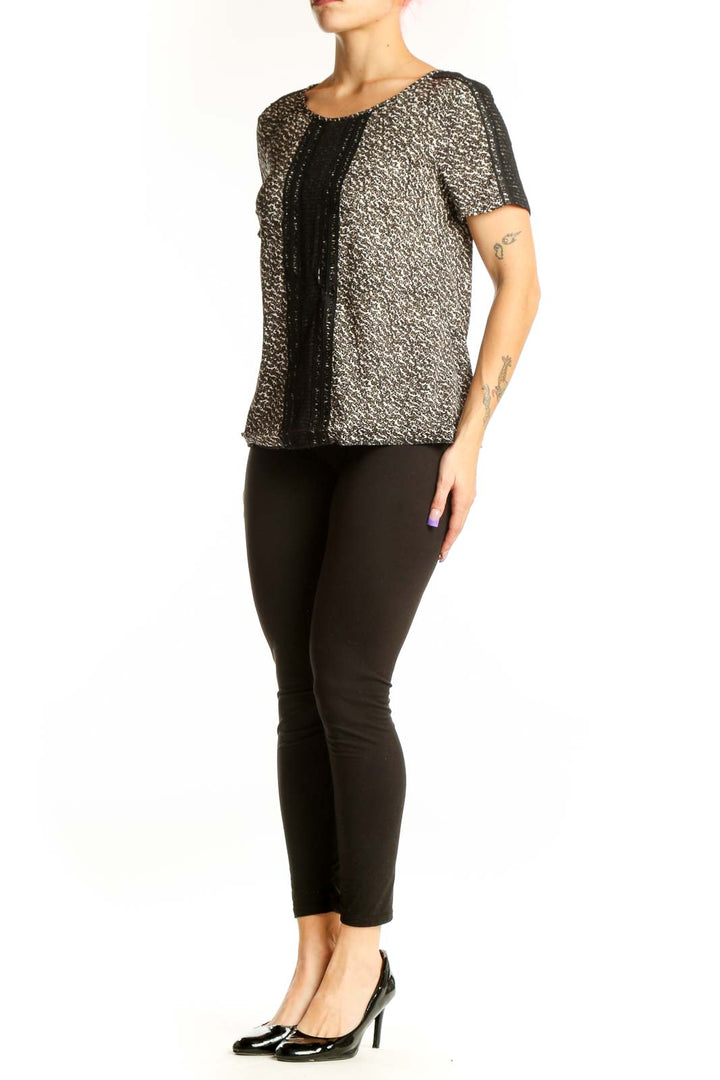Ann Taylor black metallic short-sleeve top with gold threading and textured center panel, front view