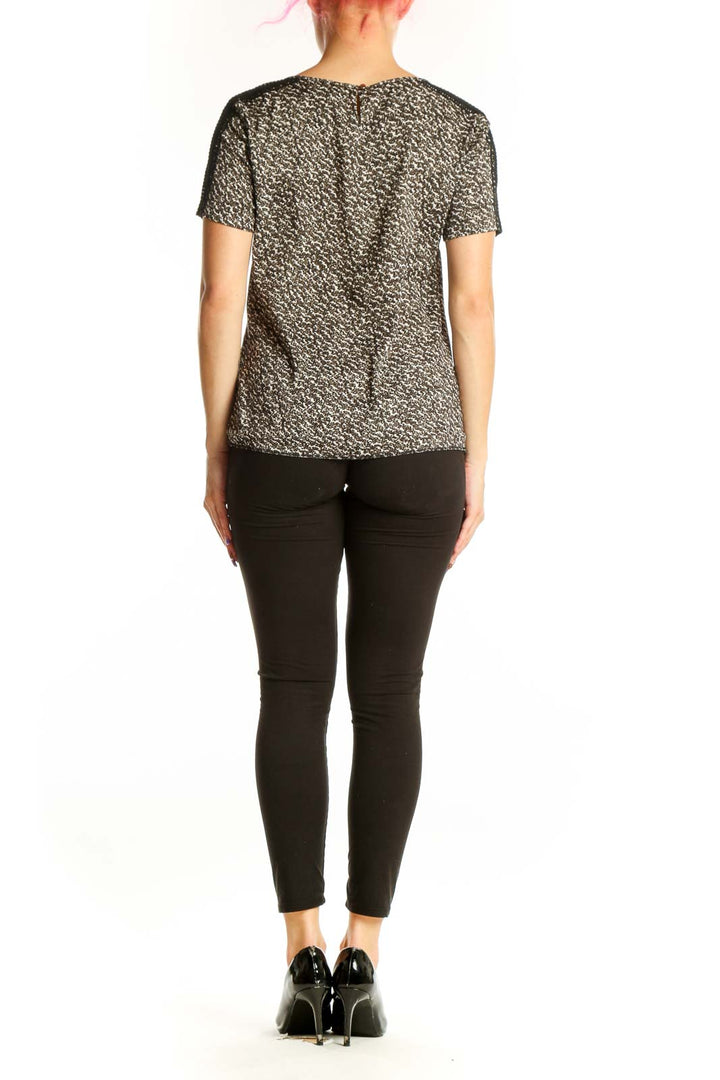 Ann Taylor black metallic short-sleeve top with gold threading and textured center panel, back view